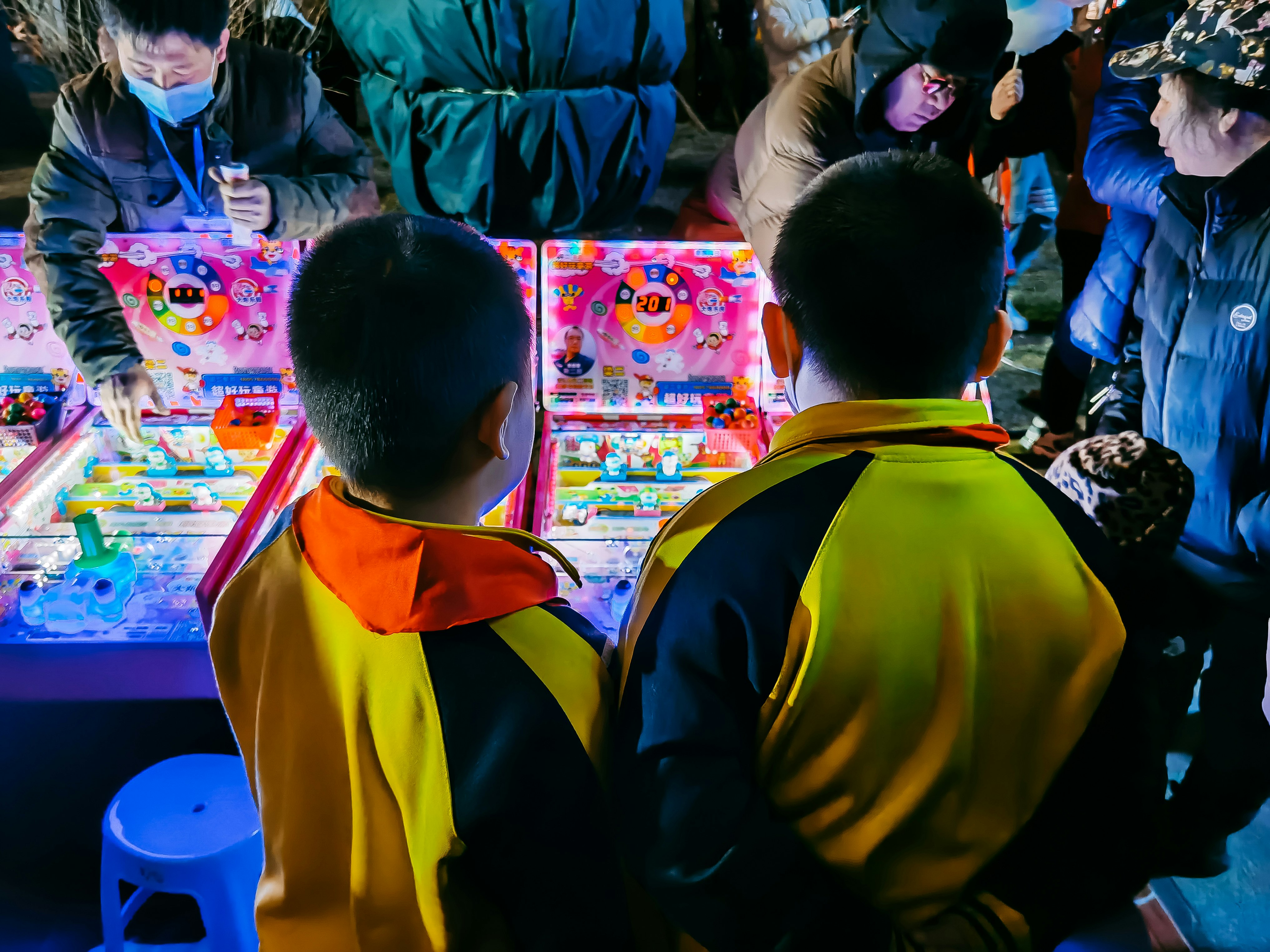 man in yellow and black jacket standing in front of children